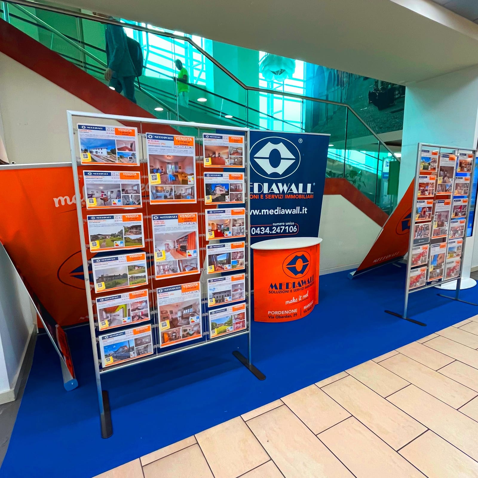 Stand dell’agenzia immobiliare Mediawall con espositori di annunci nella galleria