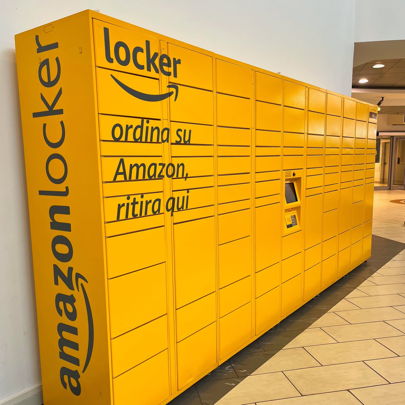 Armadietto Amazon Locker giallo installato lungo la galleria del Centro Meduna